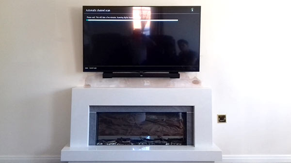 tv hung tidily on wall over modern fireplace